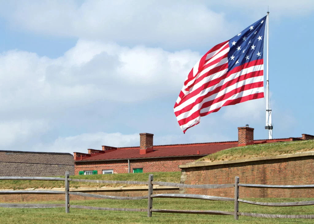 Flag behind the ramparts of Fort McHenry: From the National Park Service for Fort McHenry, a large flag (but not THE large flag) flying over the fort.; history; American flag