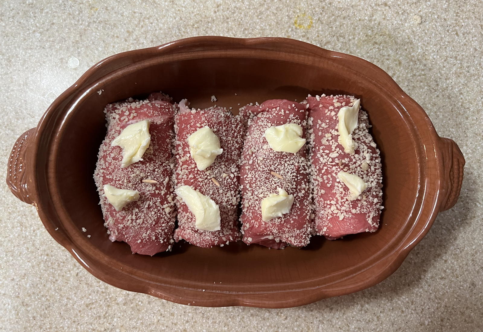 Buttered raw veal rolls: Step 2 for the Veal Steak Rolls in the 1950 Hope Lutheran (Chicago) recipe calendar: coat them and butter them.; butter; veal