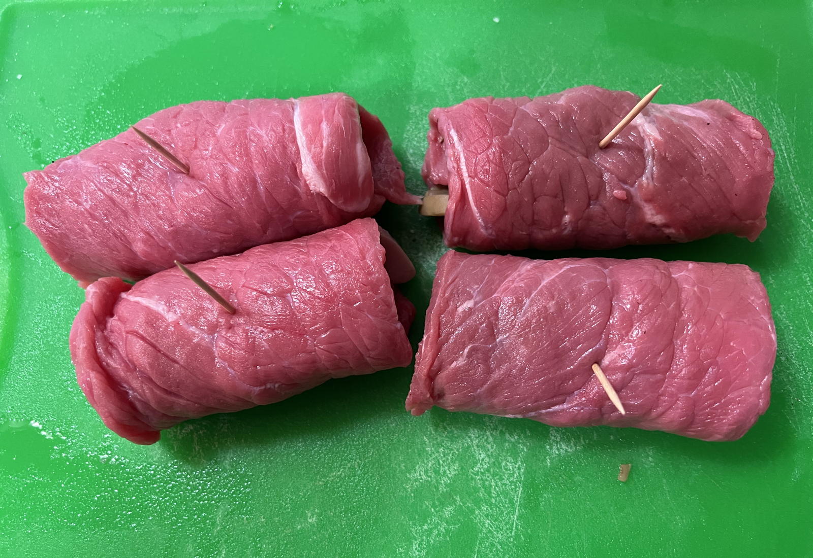 Raw veal steak rolls: Step 1 for the Veal Steak Rolls in the 1950 Hope Lutheran (Chicago) recipe calendar: roll them.; veal