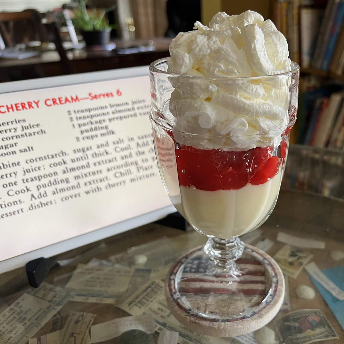 Cherry Cream with Whipped Cream: Cherry Cream from the 1950 calendar of Hope Lutheran Church of Milwaukee, Wisconsin, with whipped cream on top.; whipped cream; cherries; pudding