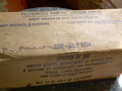 government cheese: “Pasteurized process cheddar cheese. Donated by the United States Department of Agriculture. A section 32 commodity for distribution to school lunch programs and other eligible outlets. Not to be sold or exchanged.”; cheese; government cheese