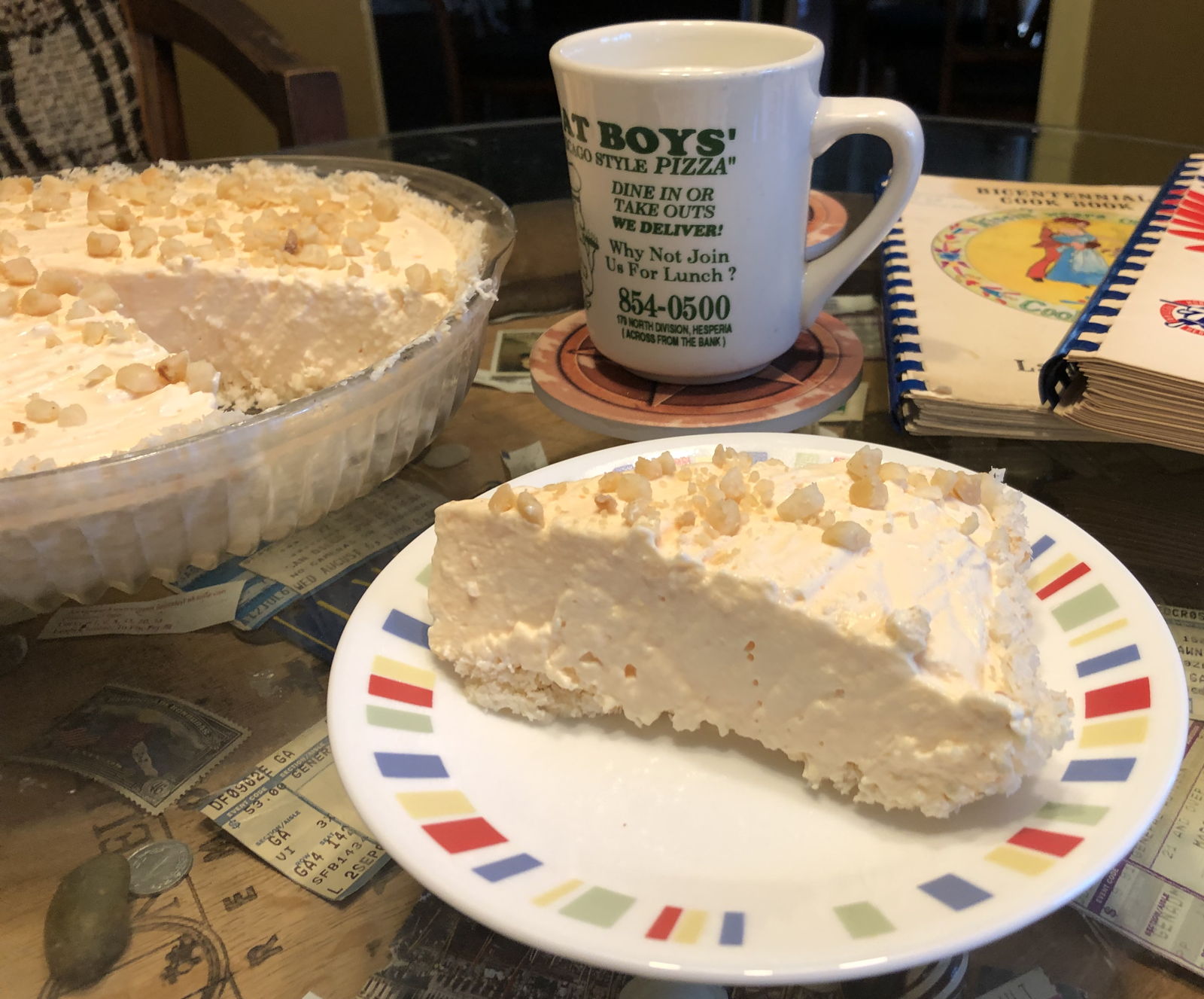 Slice of bicentennial pie: A creamy orange pie in a coconut crust topped with macadamia nuts.; Pi Day; π Day; pie; oranges; coconut; macadamia nuts