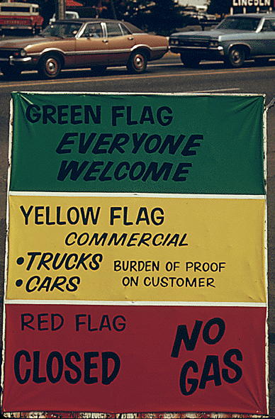 Flag policy during the 1973 oil crisis: “Gasoline dealers in Oregon displayed signs explaining the flag policy during the fuel crisis in the winter of 1973-74. As the sign says the green flag means anyone can get gas, the yellow if for commercial vehicles only and a reg flag means no gas at all.” May 1974. ARC identifier 555518.; Oregon; oil; gas