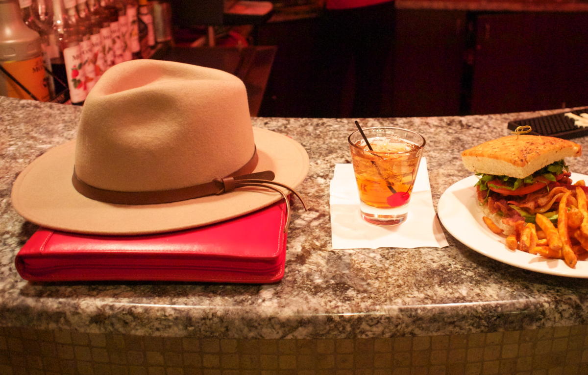 Levenger Ambi Folio and hat: Levenger Ambi Folio folded under a fedora.; alcohol; writing tools; hats